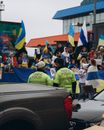 People in Green and Yellow Shirts Standing Near Cars