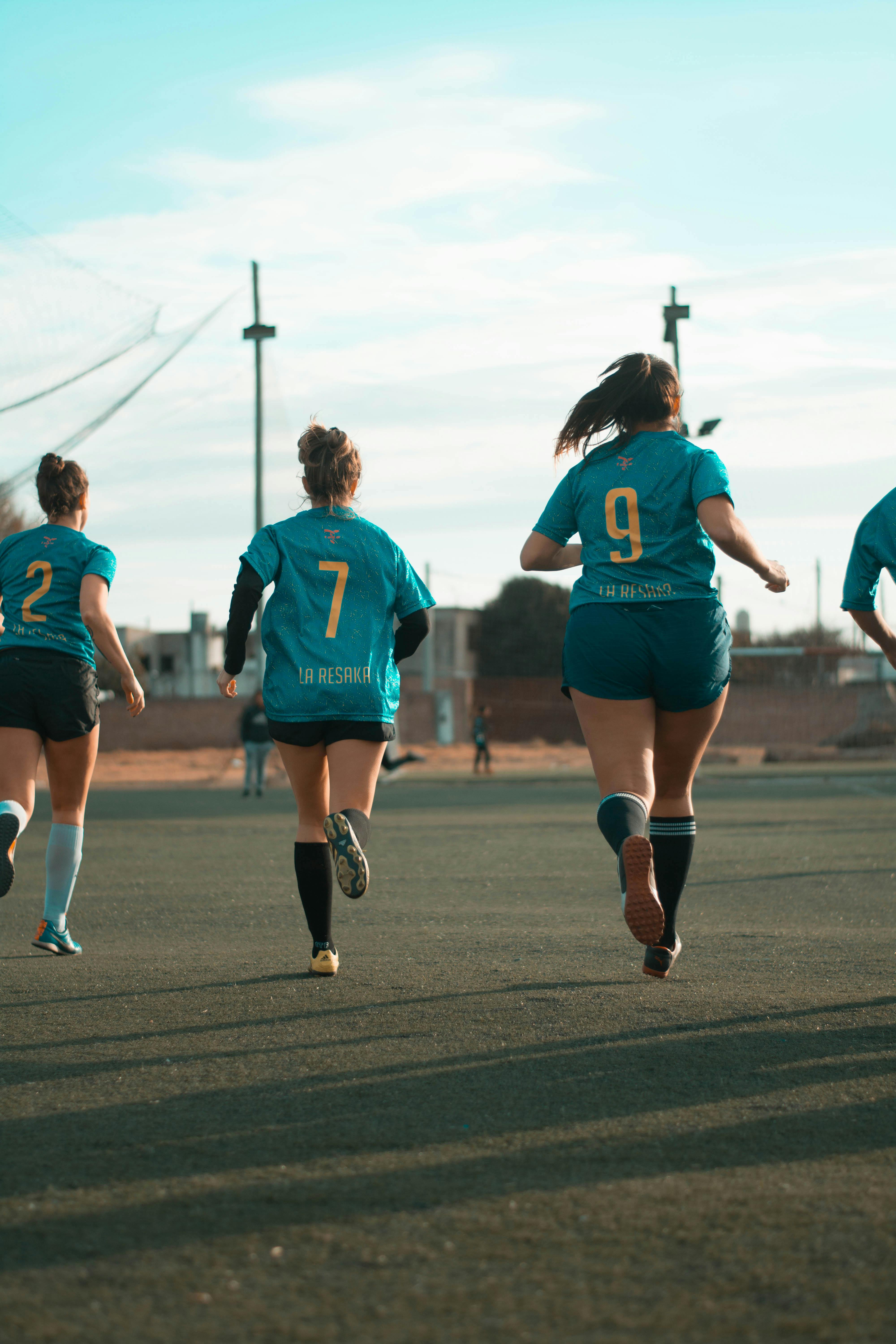 three women wearing blue jersey shirt running