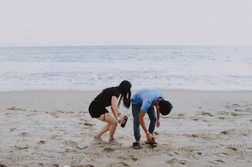 무료 남자와여자가 해변에 서있는 스톡 사진