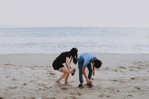 Two friends picking up sandals on Bucerías beach in Mexico, enjoying a relaxing day by the sea.