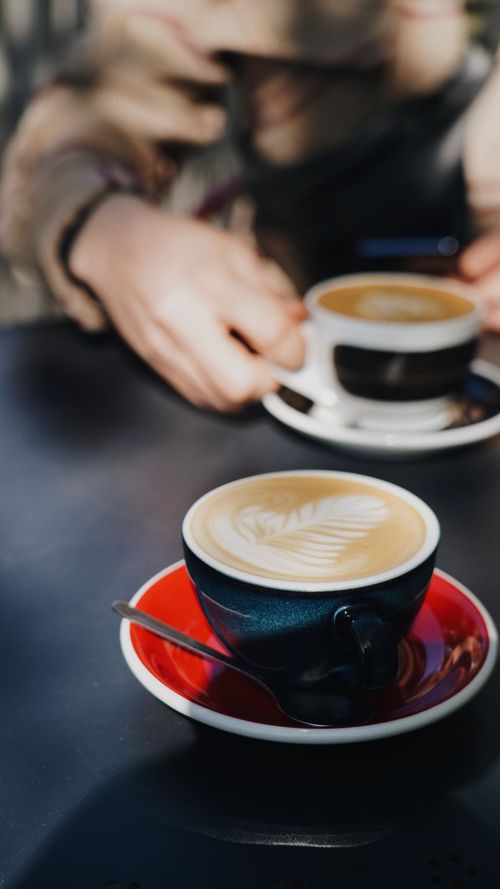 Free Elegant latte art in a ceramic cup on a table, creating a cozy cafe vibe. Stock Photo