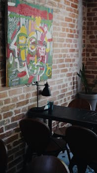 Cozy cafe interior with brick wall and abstract art, perfect for creative inspiration.