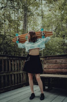 Stylish woman poses with longboard in a scenic outdoor setting, capturing a blend of fashion and adventure.