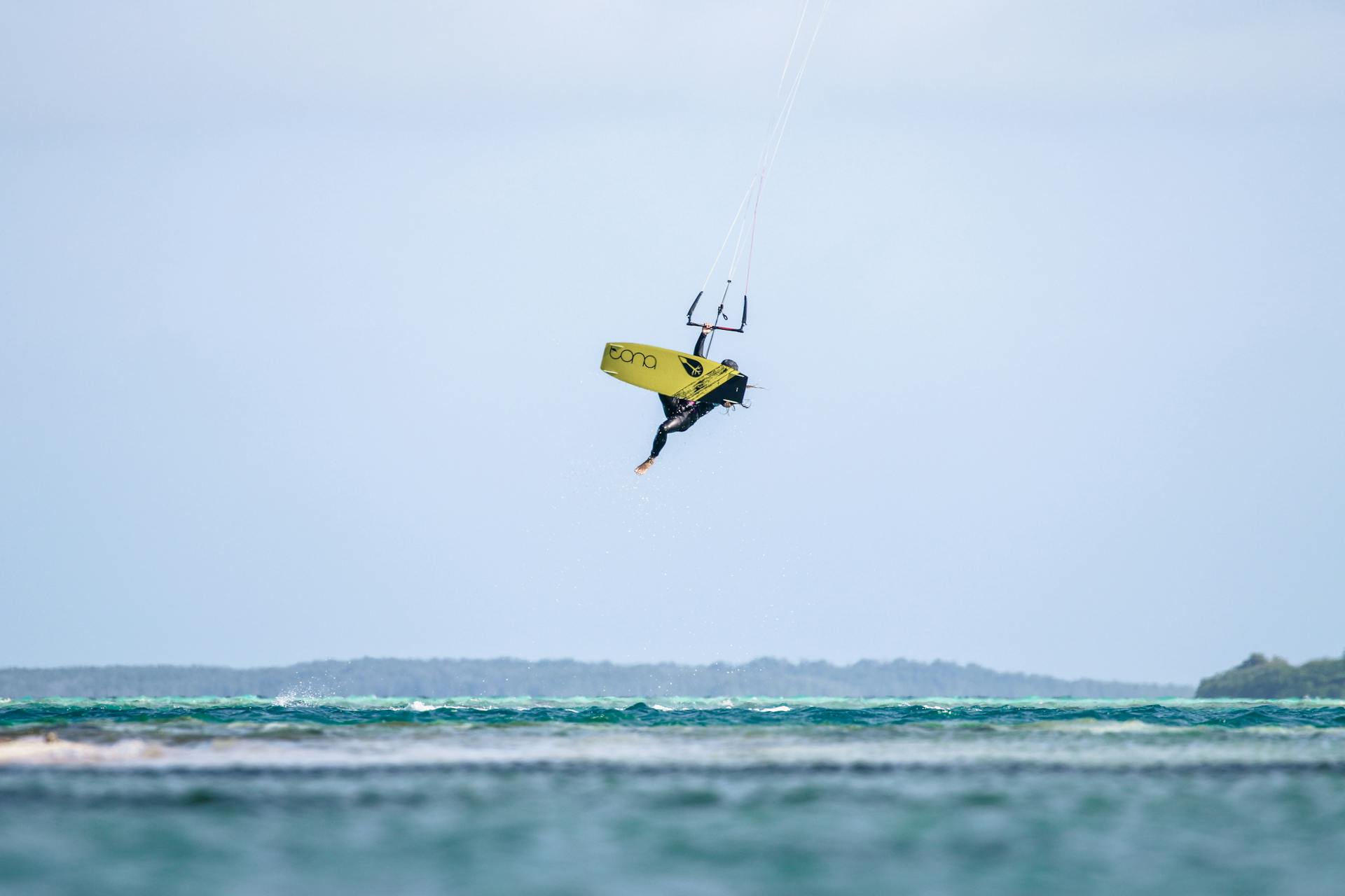 A kiteboarder catches air over the ocean in Venezuelan waters, showcasing high-flying water sports action.