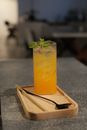 Orange Juice in Clear Drinking Glass on Brown Wooden Coaster