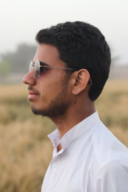 Free Profile portrait of a young man wearing sunglasses in a natural outdoor setting. Stock Photo
