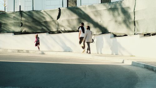 Free A family enjoying a sunny day walk in an urban setting, capturing everyday life. Stock Photo