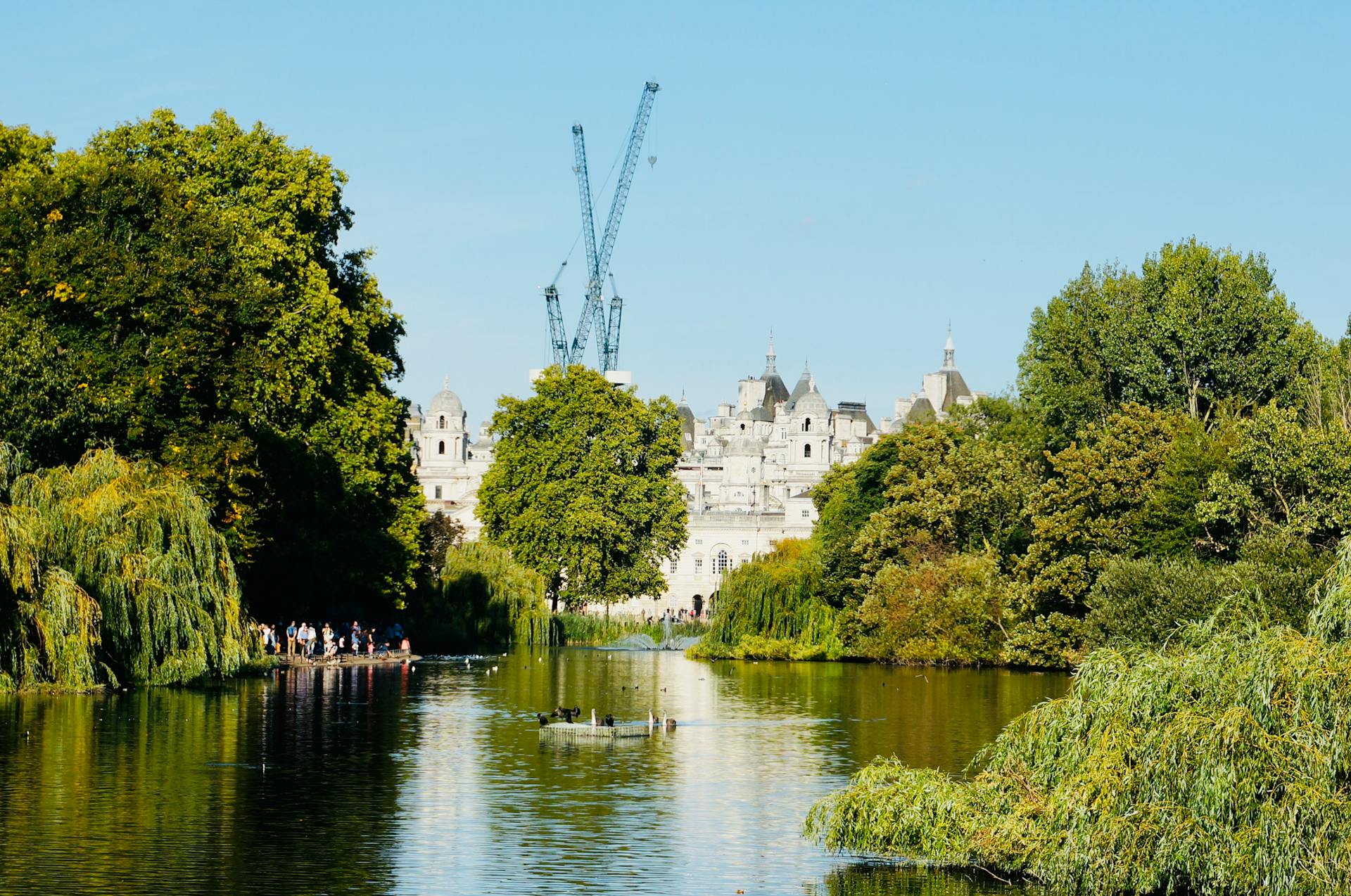 Tranquil view of St James's Park with a historic building and lush trees in London.