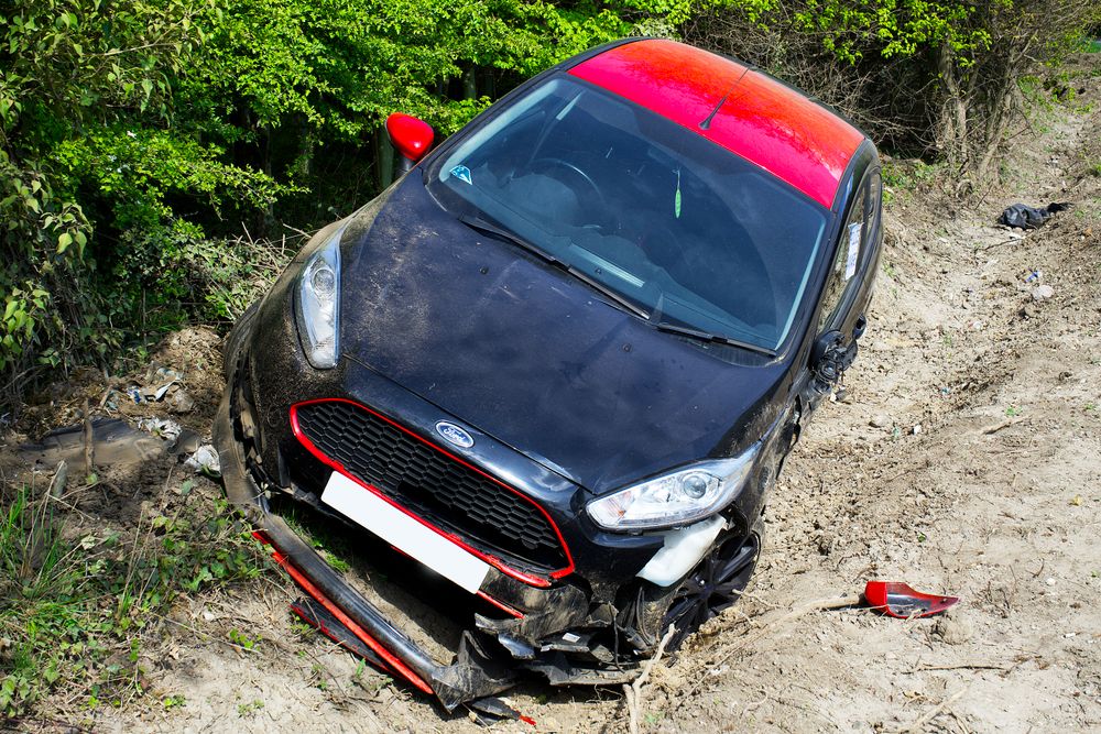 Damaged white car after a roadway accident