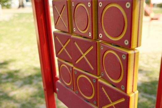 Colorful tic tac toe game on playground equipment in sunlight.