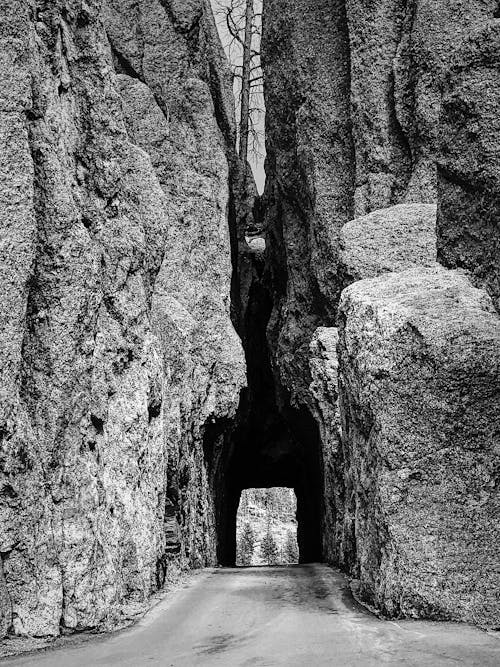 Stone cave between asphalt road in daylight