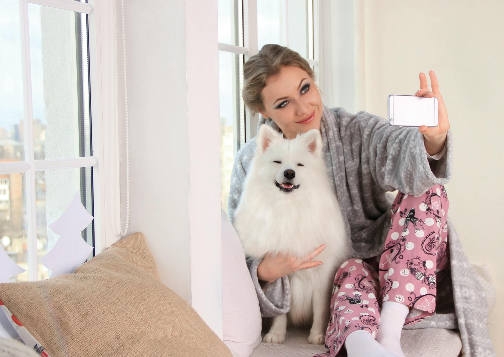 Woman Taking a Photo of Herself With White Dog