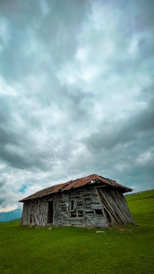 Abandoned Wooden House on Green Grass 