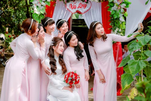 Women in White Ao Dai Dress Taking a Group Selfie