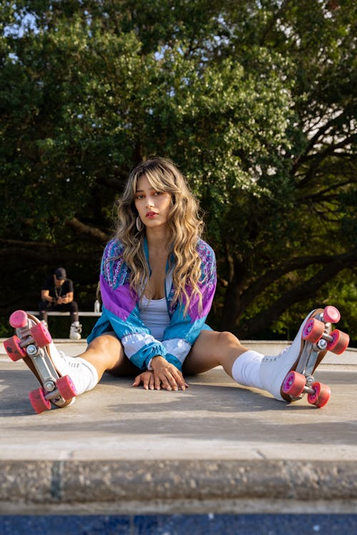 Woman in Roller Skates Sitting in a Skatepark