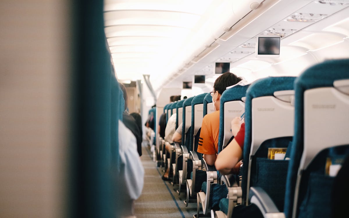 Interior view of airplane cabin showing passengers seated during a flight.