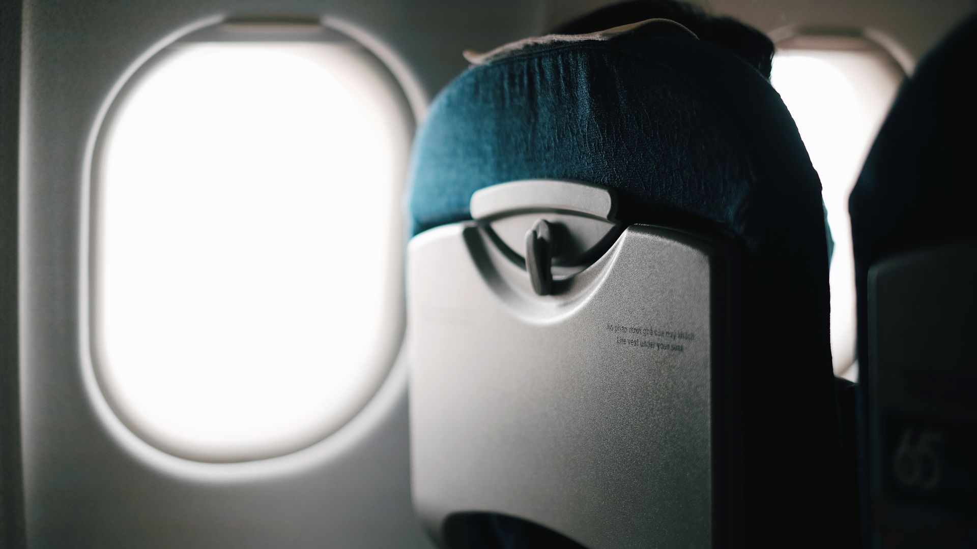 Modafinil for Long Haul Flights: Your Ultimate Guide View of an airplane seat with window revealing a bright sky outside — modafinil for long haul flights