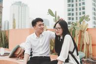Man in White Dress Shirt Sitting Beside Woman in White Long Sleeve Shirt