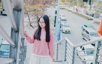Woman in Pink Long Sleeve Shirt and White Skirt Standing Near White Metal Railings