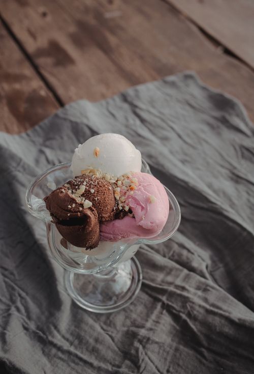 Free A tempting glass of chocolate, vanilla, and strawberry ice cream served elegantly. Stock Photo
