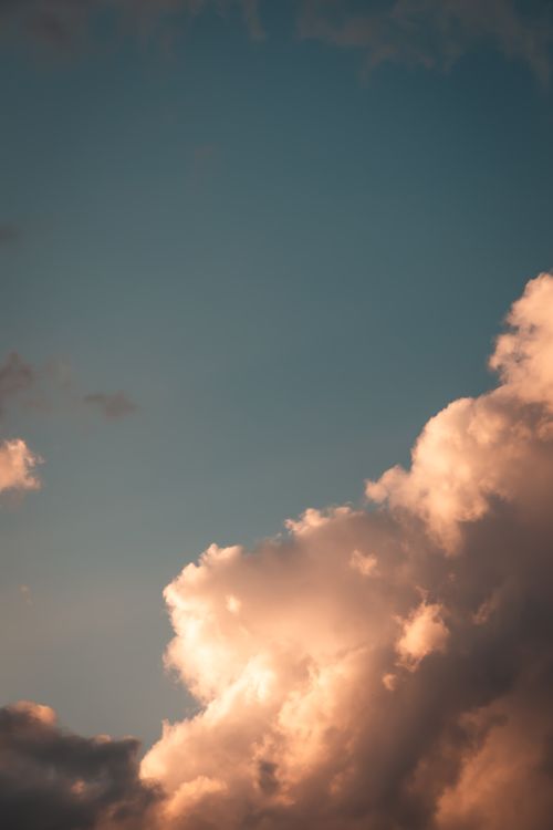 Free Glowing clouds with a serene blue sky background create a calming scene at sunset. Stock Photo