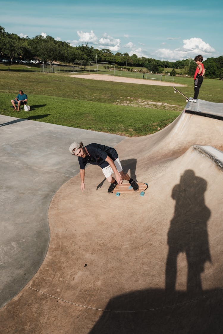 A Man Longboarding At The Skate Park