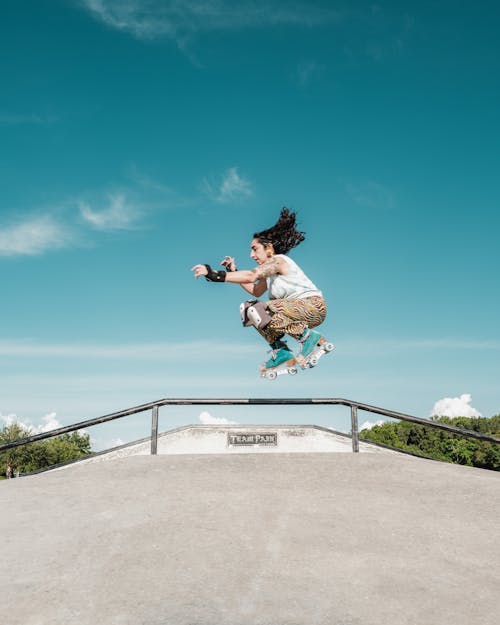 Skater Jumping over Railing in Skate Park