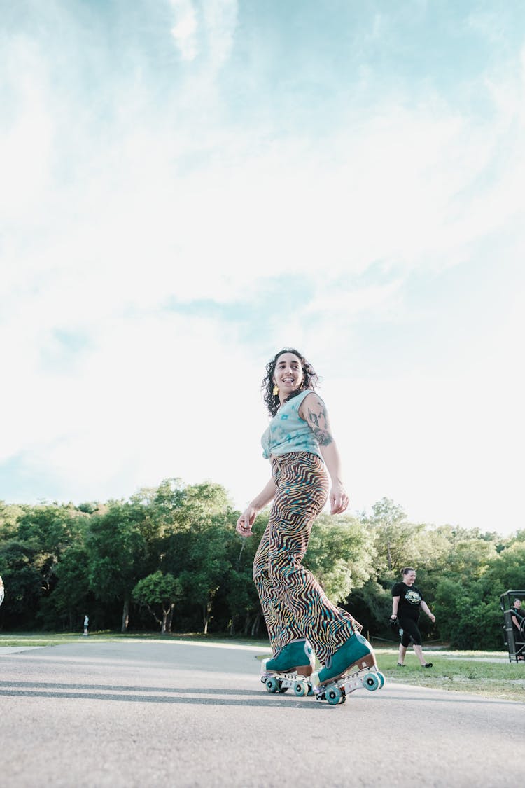 Woman In Sleeveless Top And Printed Pants Roller Skating