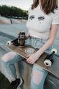 Woman in White T-shirt and Blue Denim Jeans Sitting on Brown Wooden Table With Brown