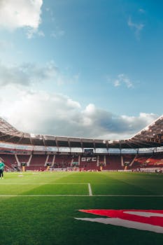 A scenic view of a football field in Geneva stadium with vibrant green grass and a clear blue sky.