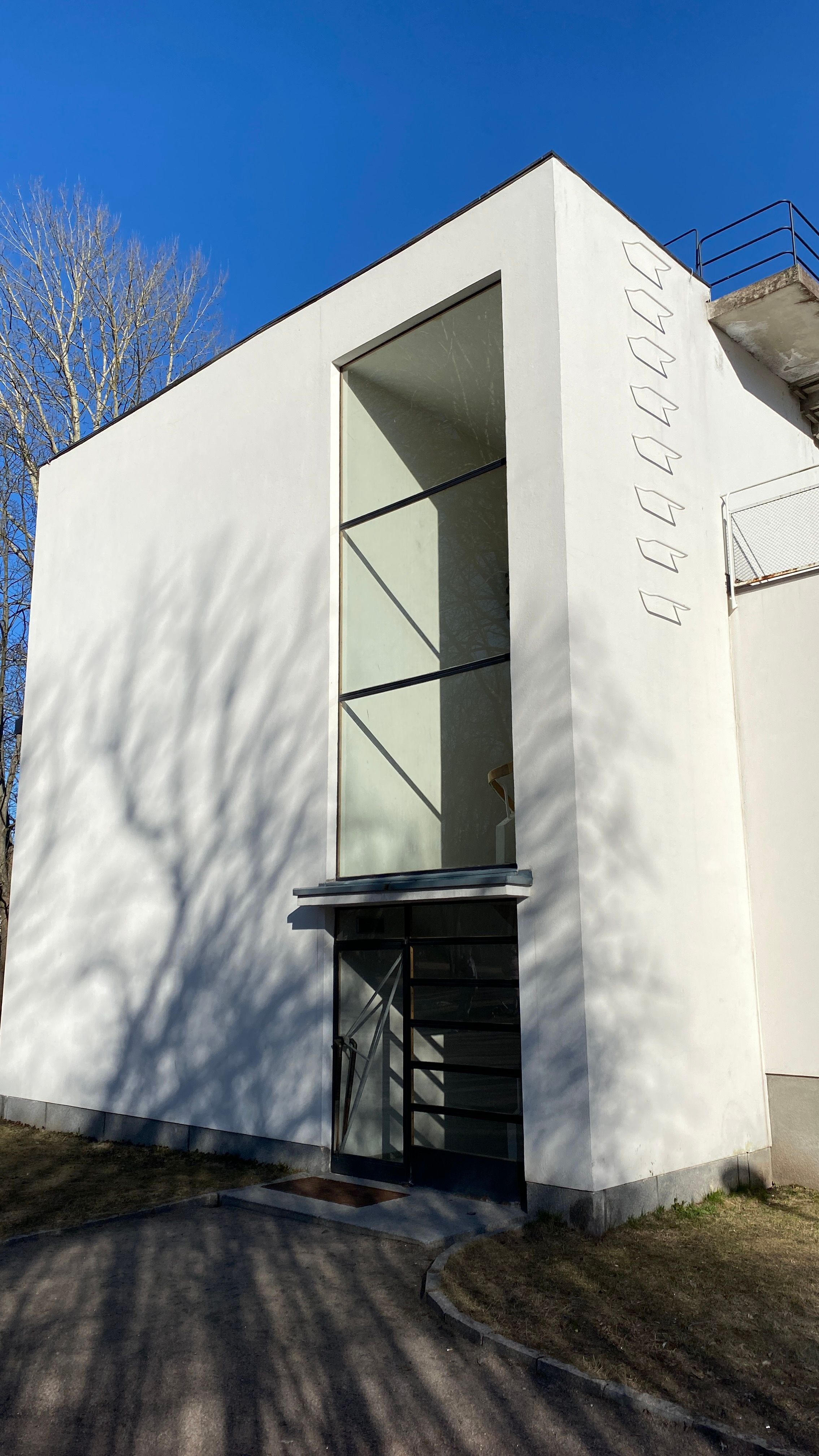 Modern white building with glass facade in Vyborg, under clear blue sky.
