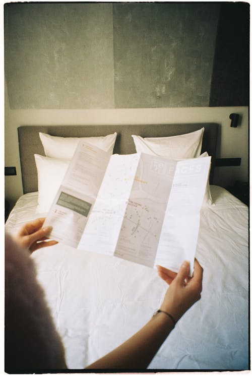 Woman Holding Paper in Bedroom