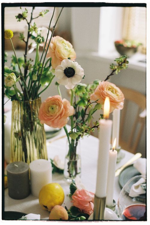 Free Charming bouquet of flowers and candles on a table setup for a cozy indoor setting. Stock Photo