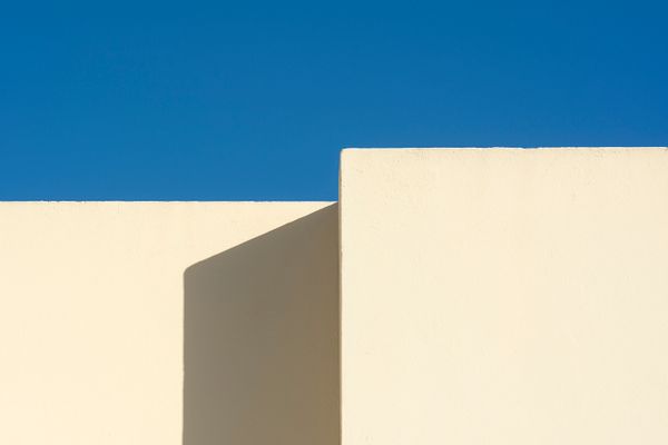 Sunlit white wall shapes against blue sky, photo by Jan van der Wolf on Pexels