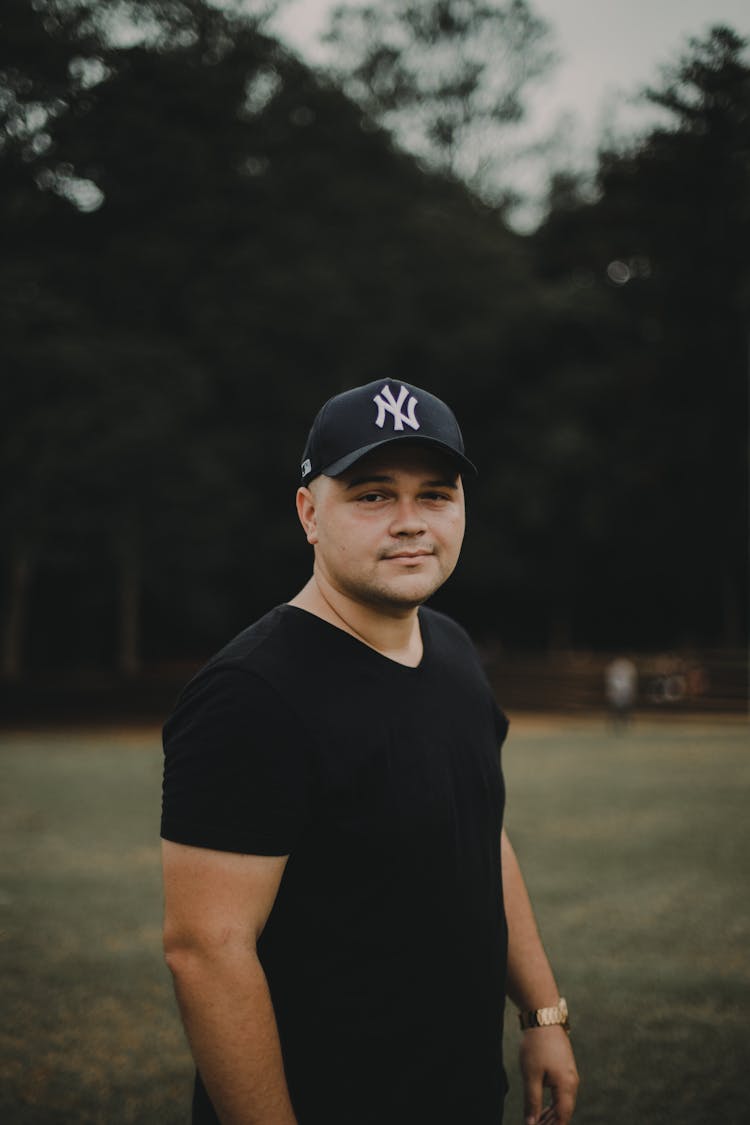 A Man In A Black Shirt And Cap