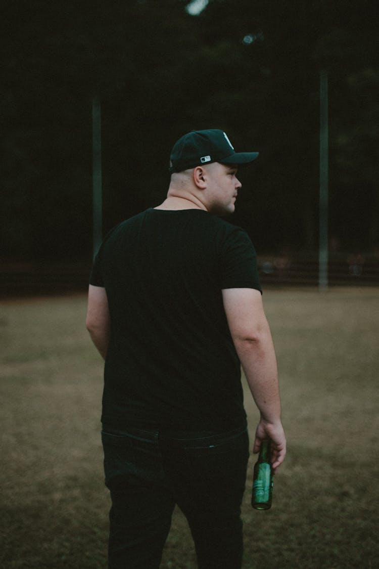 A Man In Black Shirt Holding A Bottle Of Beer