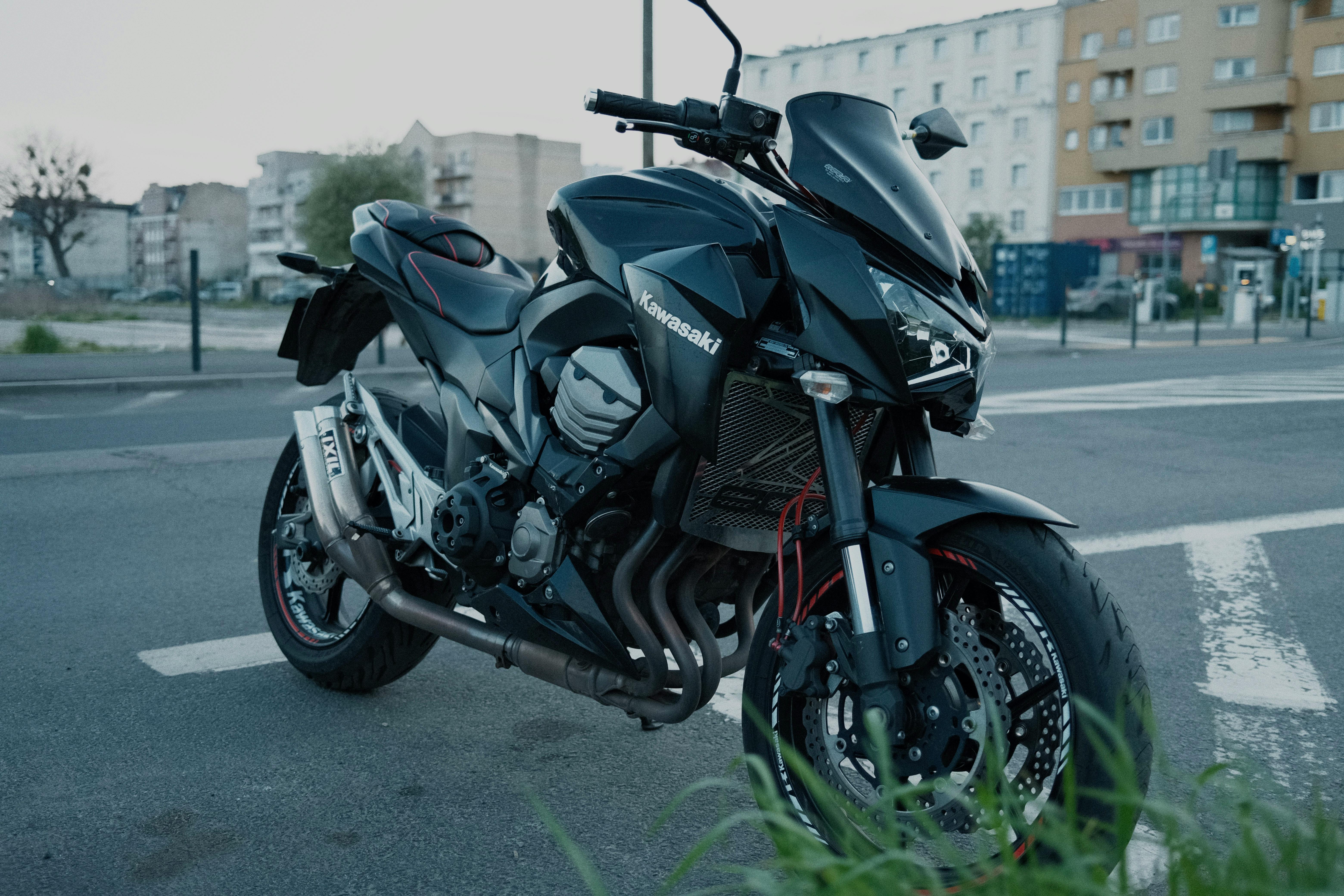 Sleek Kawasaki motorcycle with sporty design parked on a city street.