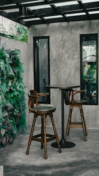 Warm and inviting coffee shop interior featuring wooden chairs and table against a rustic backdrop.