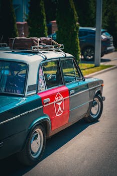 A classic Lada car with a roof suitcase captured on an urban street, embodying retro travel charm.