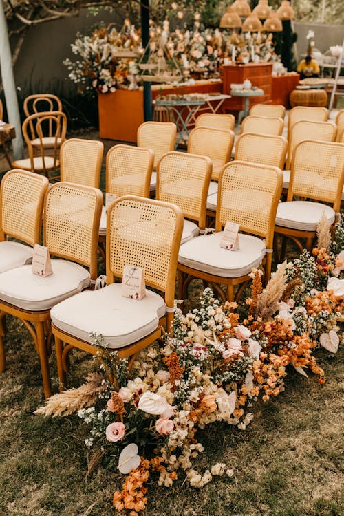 Free Rows of chairs with floral decorations at an outdoor wedding ceremony setup. Stock Photo Free Rows of chairs with floral decorations at an outdoor wedding ceremony setup. Stock Photo