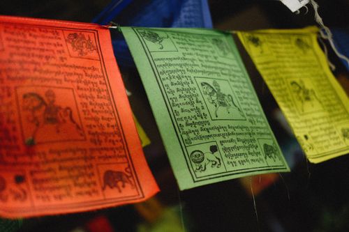Free Colorful Tibetan prayer flags with traditional scriptures hanging against a dark background. Stock Photo