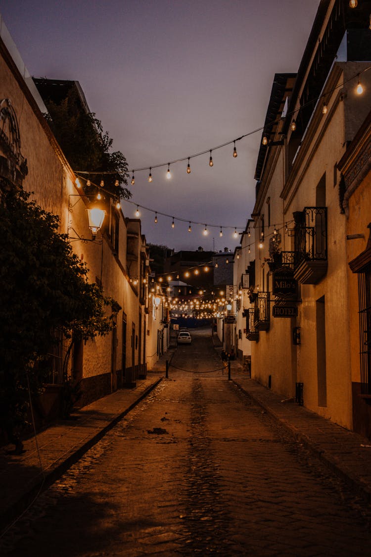 A String Lights Hanging On The Street At Night