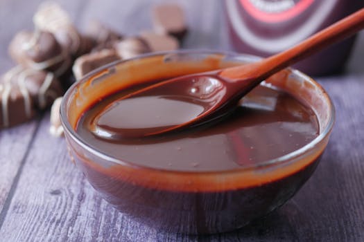 Close-up of melted chocolate in a glass bowl, ideal for baking or dessert toppings.