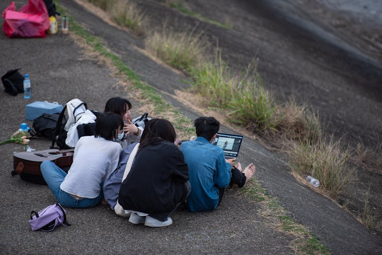 Young People Using A Laptop Outdoors