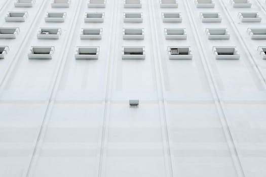 Low angle view of a modern white building facade with rows of windows in Taipei, Taiwan.