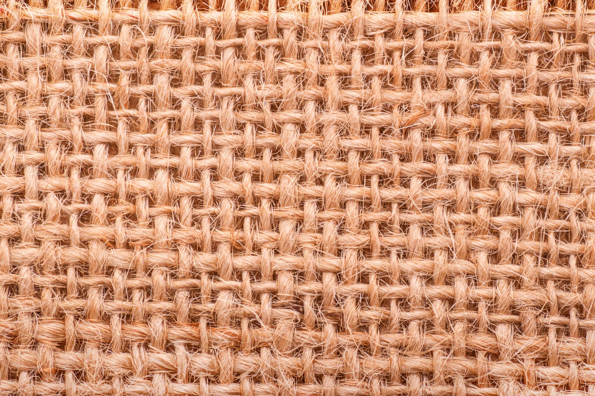 Close-up of a rough jute weave texture showing intricate fibrous pattern.