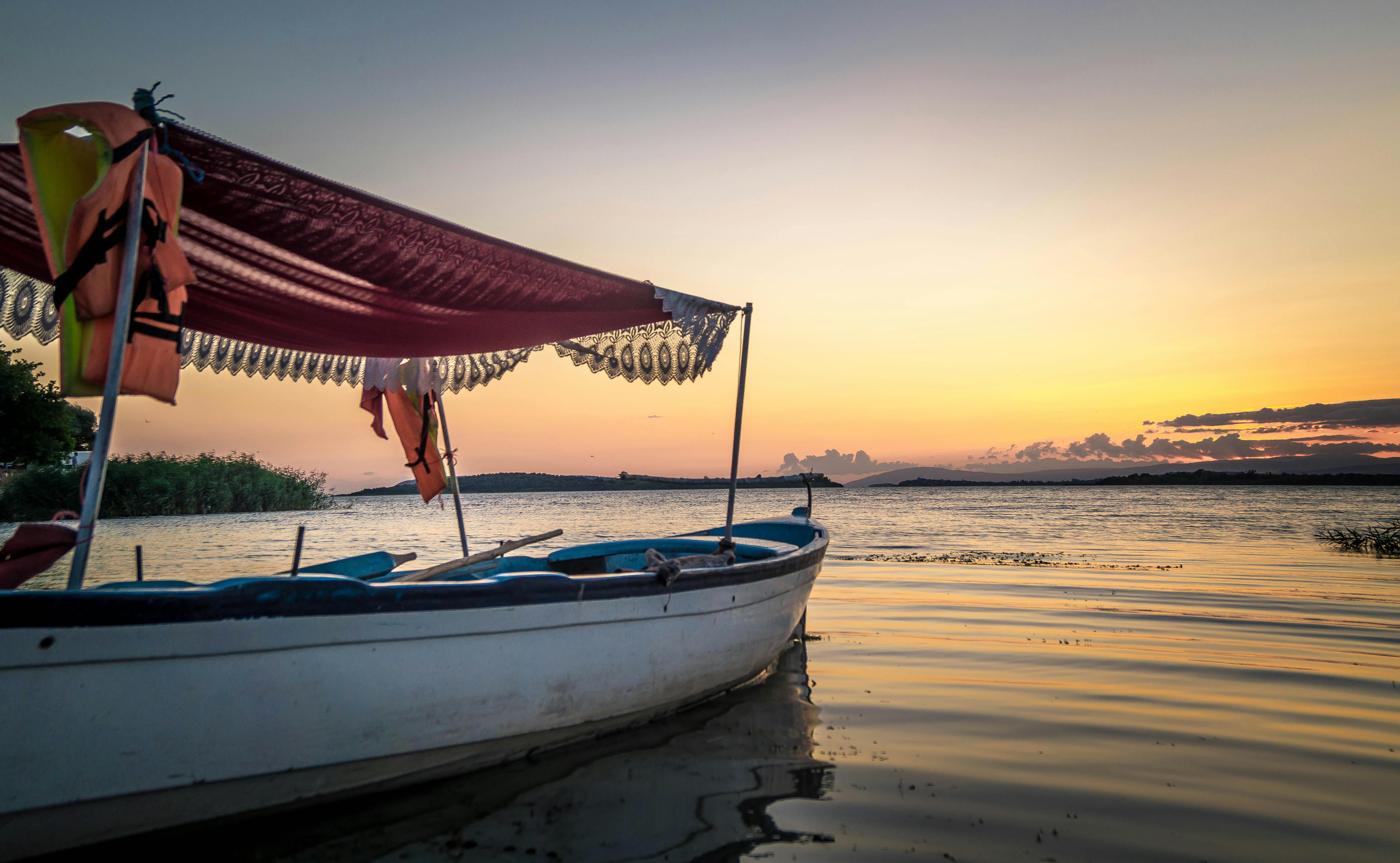 日落时分，一艘船静静泊在湖面上，很适合休闲主题