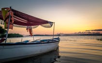 日落时分，一艘船静静泊在湖面上，很适合休闲主题