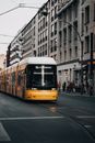 Yellow and White Tram on Road Near White Concrete Building