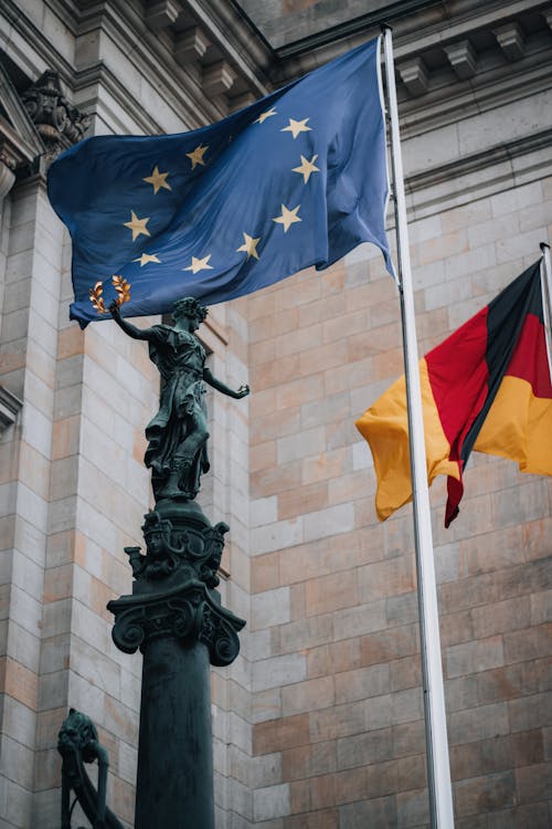 Black Concrete Statue Beside the Flag